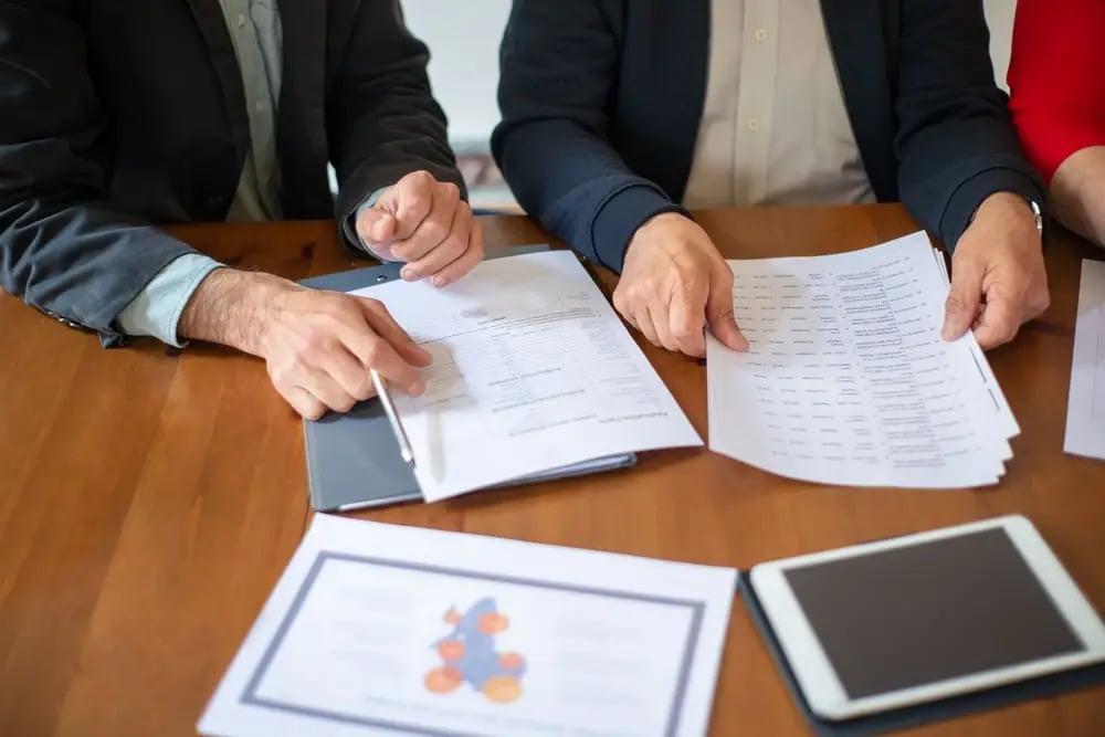 Colleagues reviewing documents and charts at a meeting table
