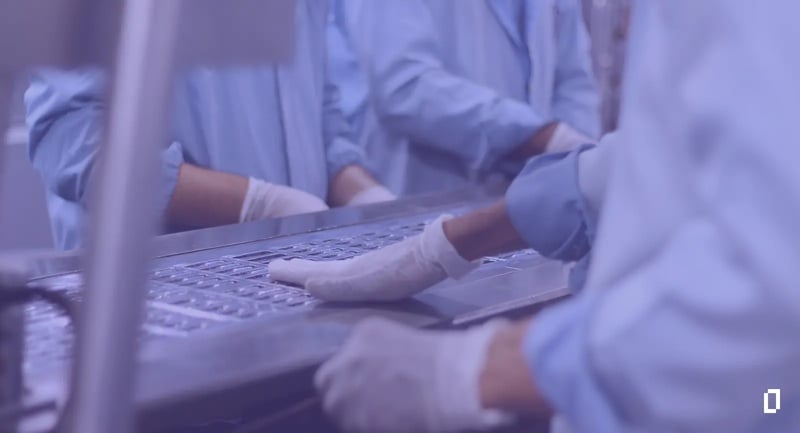 Scope 3 for pharma contract manufacturers: gloved workers handling blister packs on a tablet packing line