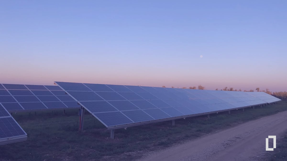 Rows of solar panels in a field at dusk, illustrating on-site renewable energy as a substitution lever
