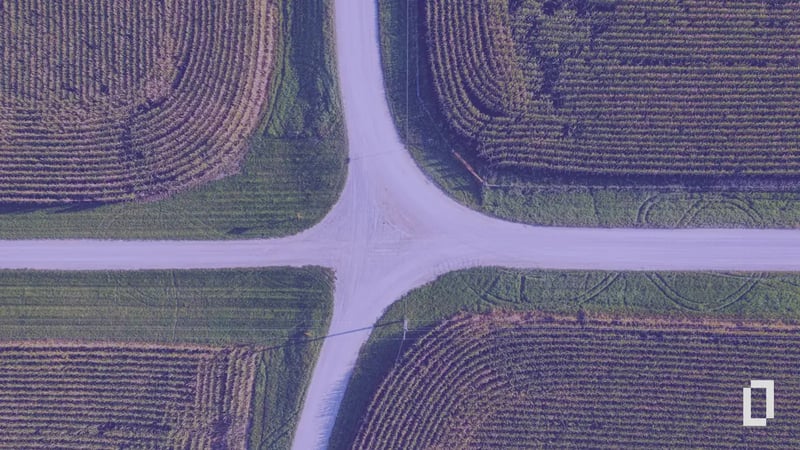 Aerial view of a crossroads between farm fields, with a purple tint and the Terrascope logo: four routes to a carbon footprint.