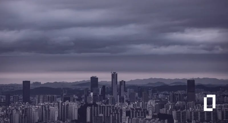 South Korea climate disclosure rules: Seoul skyline beneath storm clouds with mountains behind