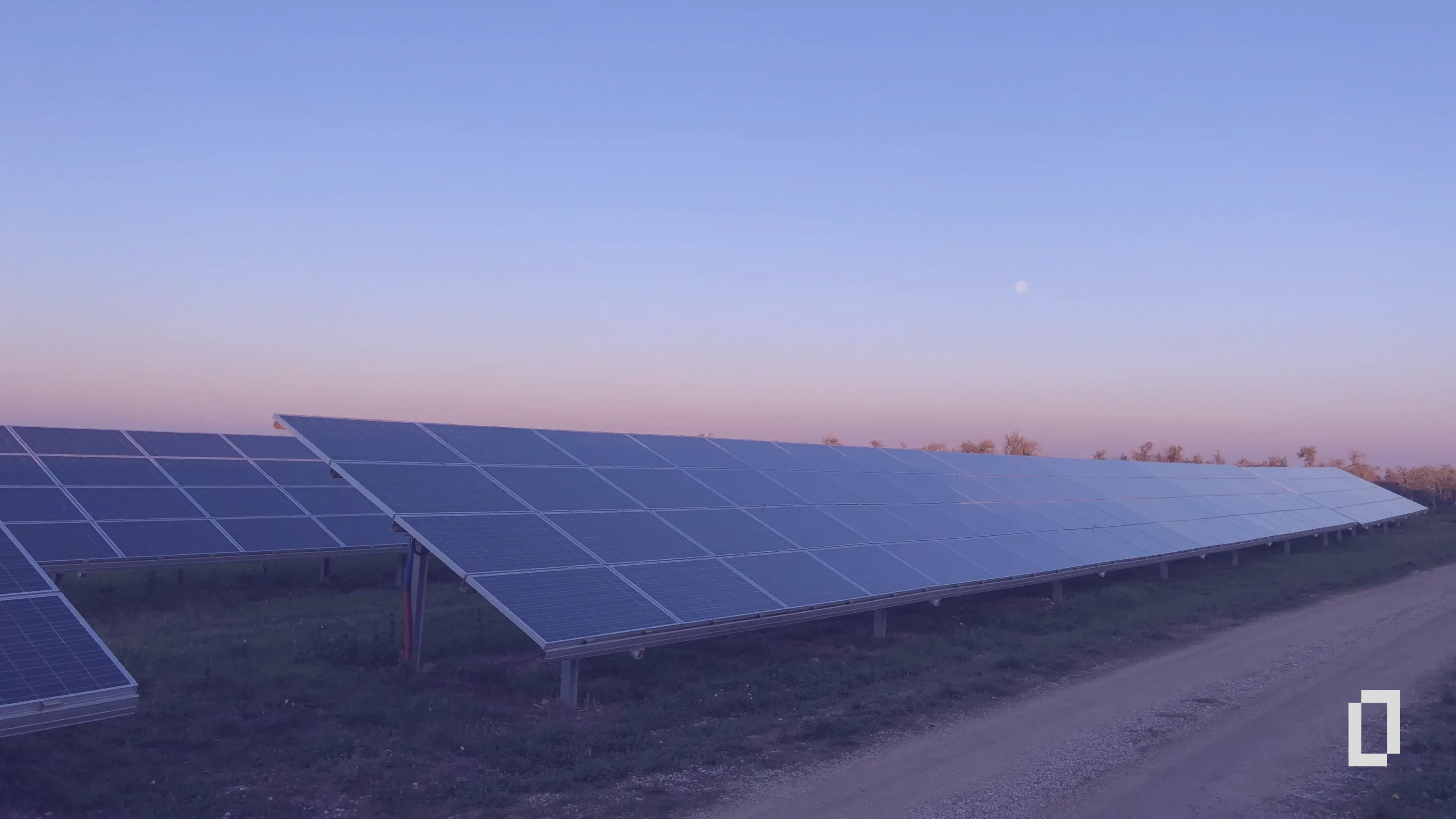 Rows of solar panels in a field at dusk, illustrating on-site renewable energy as a substitution lever