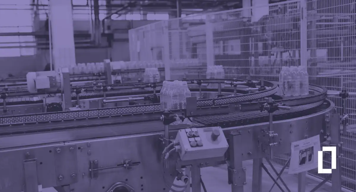 Product carbon footprint software: packs of bottled water on a curved conveyor in a beverage bottling plant
